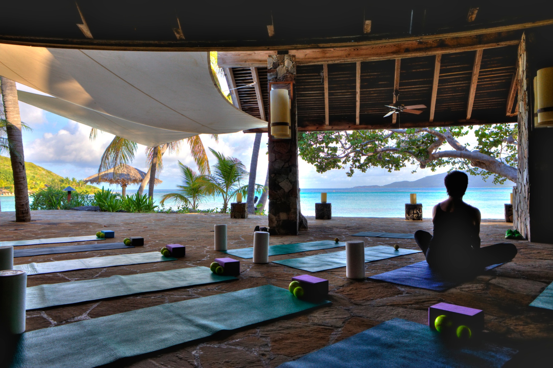Oceanfront yoga pavilion with mats set up overlooking turquoise Caribbean water